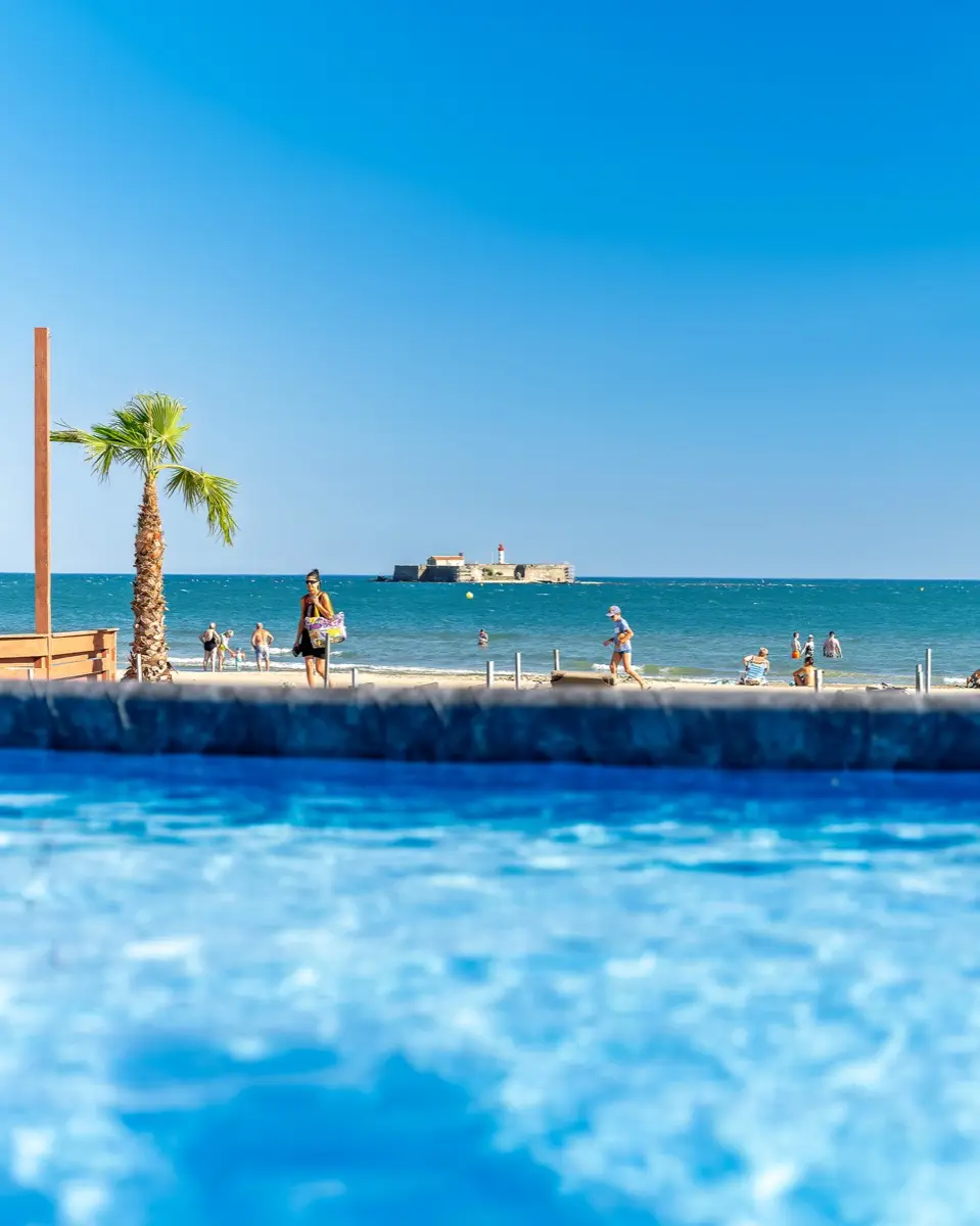 La piscine, son palmier et le Fort Brescou à l'horizon