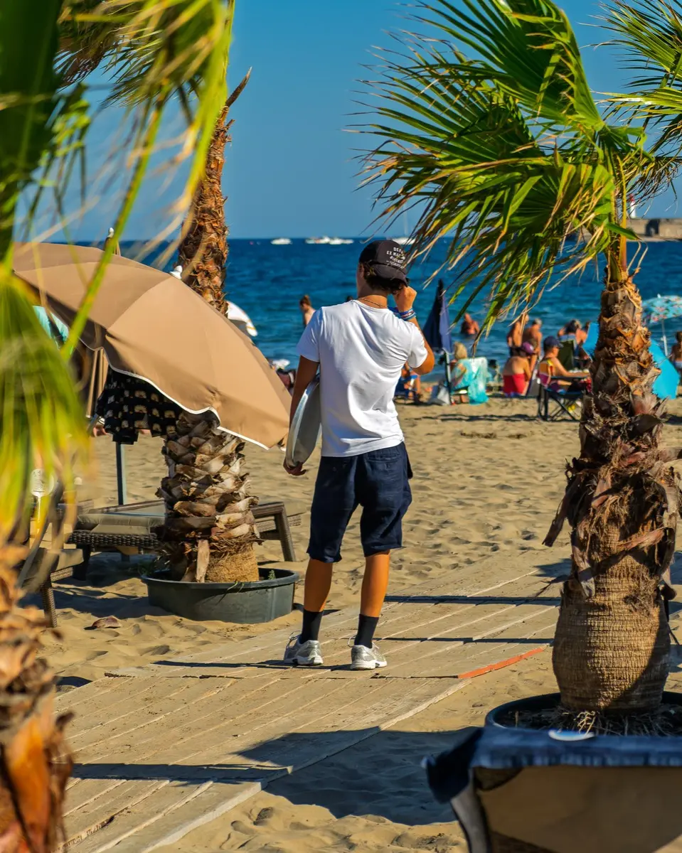 L'allée bordée de palmiers qui mène à la plage