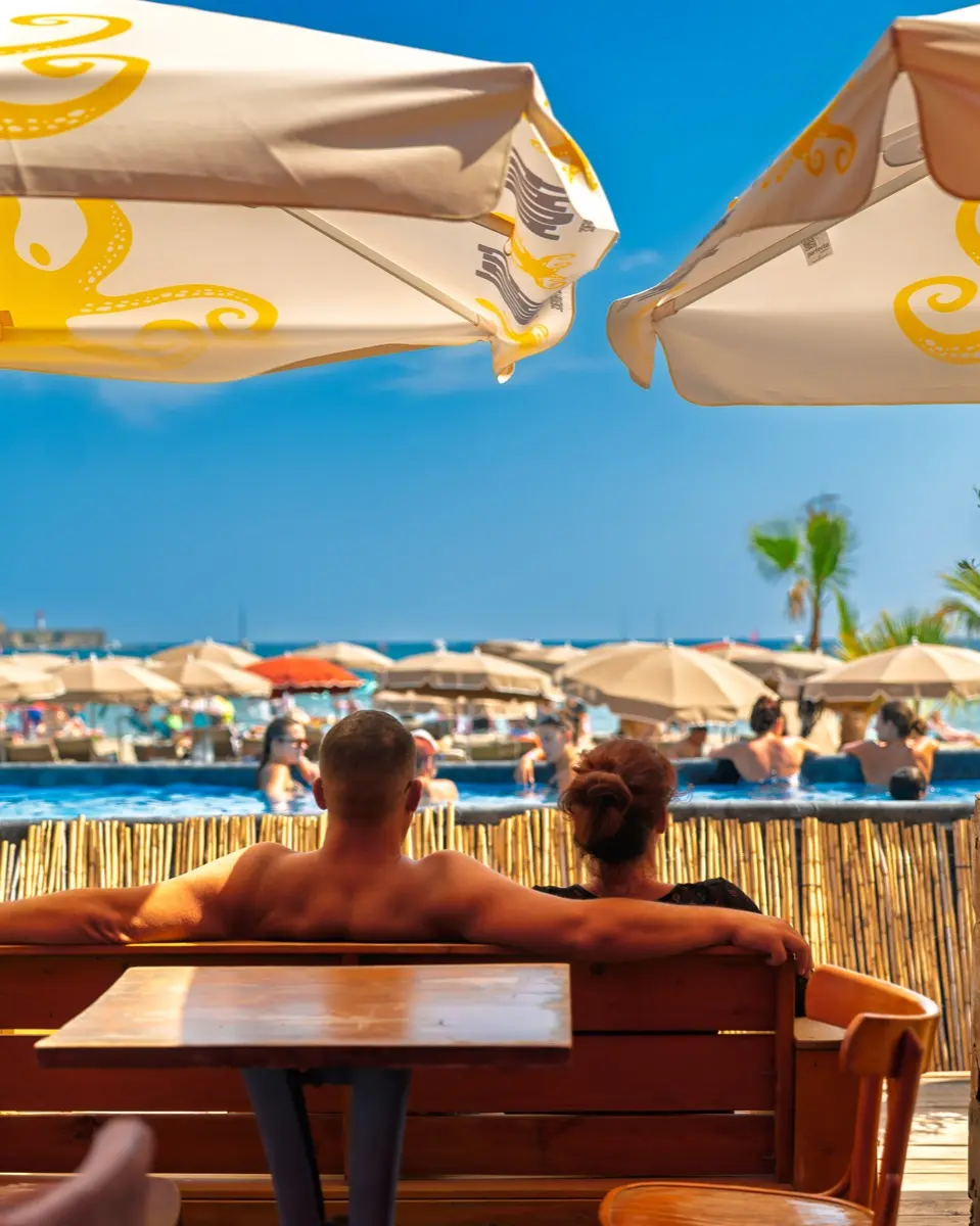 Moment de détente à l'ombre des parasols, devant la piscine