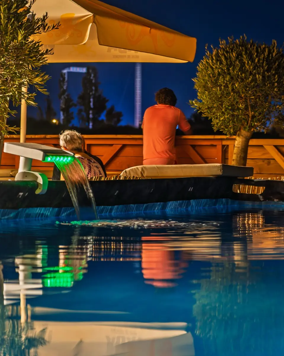 La piscine illuminée à la nuit tombée